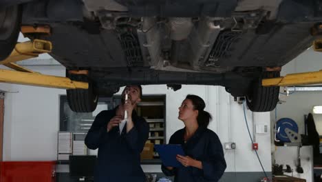 mecánicos revisando un coche