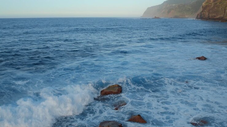 Le onde dell'oceano si scontrano su una costa rocciosa
