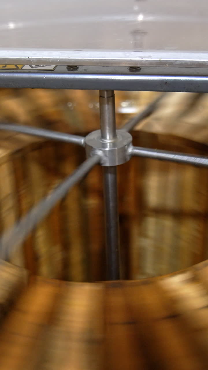 Electric machine for honey removal rotating frames. Close up. Honey extractor working with opened lid. Top view. Vertical video