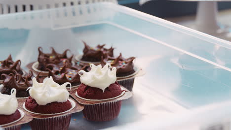 panadero colocando un muffin helado en una bandeja de muffins en una panadería