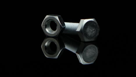 industrial hardware: bolt and nut on reflective surface