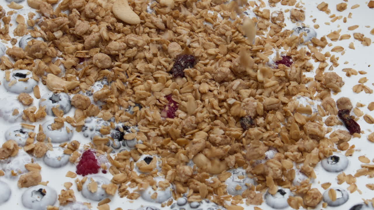 yogur saludable bayas de granola súper cámara lenta de cerca. postre sabroso de leche.