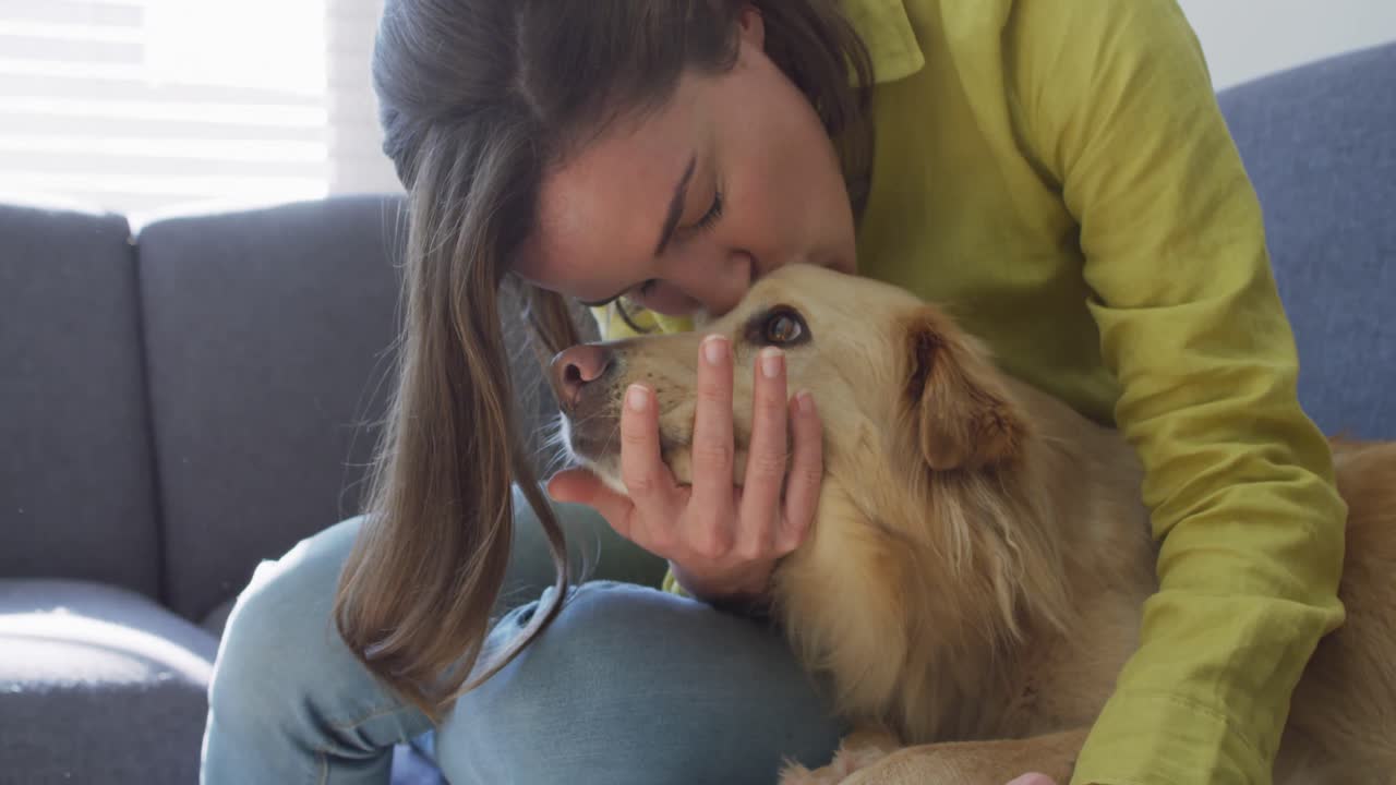 백인 여성이 개와 함께 소파에 앉아 미소 짓고 있습니다.