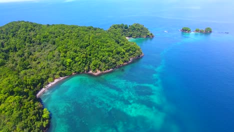 a sailboat anchored offshore from afuera island in panama surrounded by incredible turquoise blue water on a sunny day in paradise