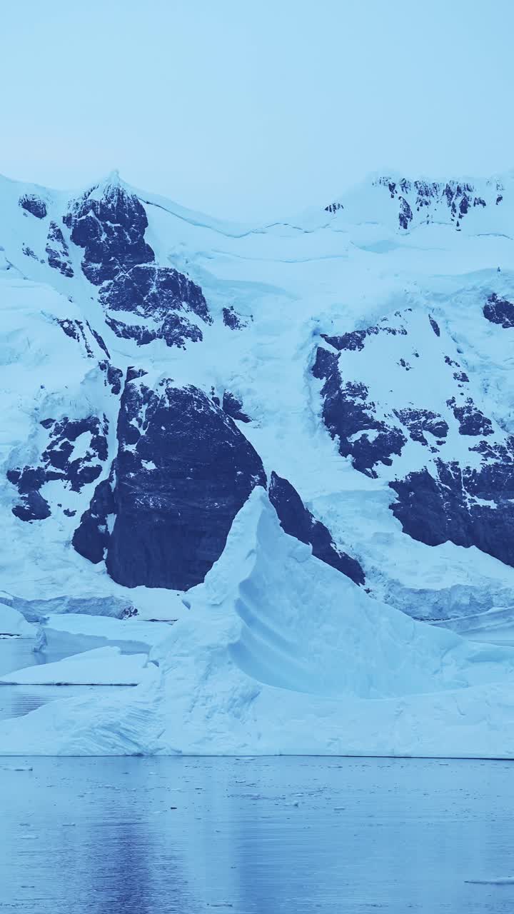 antártida icebergs y montañas azules, iceberg flotando en el agua del océano en video vertical para redes sociales, instagram reels y tiktok, península antártica paisaje marino de hielo de invierno