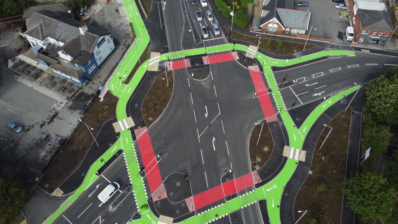 Aerial view vehicles driving on St Helens CYCLOPS traffic optimisation junction crossroad intersection, Tilt down flyover shot