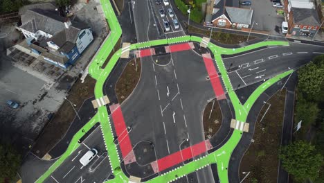 Aerial-view-vehicles-driving-on-St-Helens-CYCLOPS-traffic-optimisation-junction-crossroad-intersection,-Tilt-down-flyover-shot