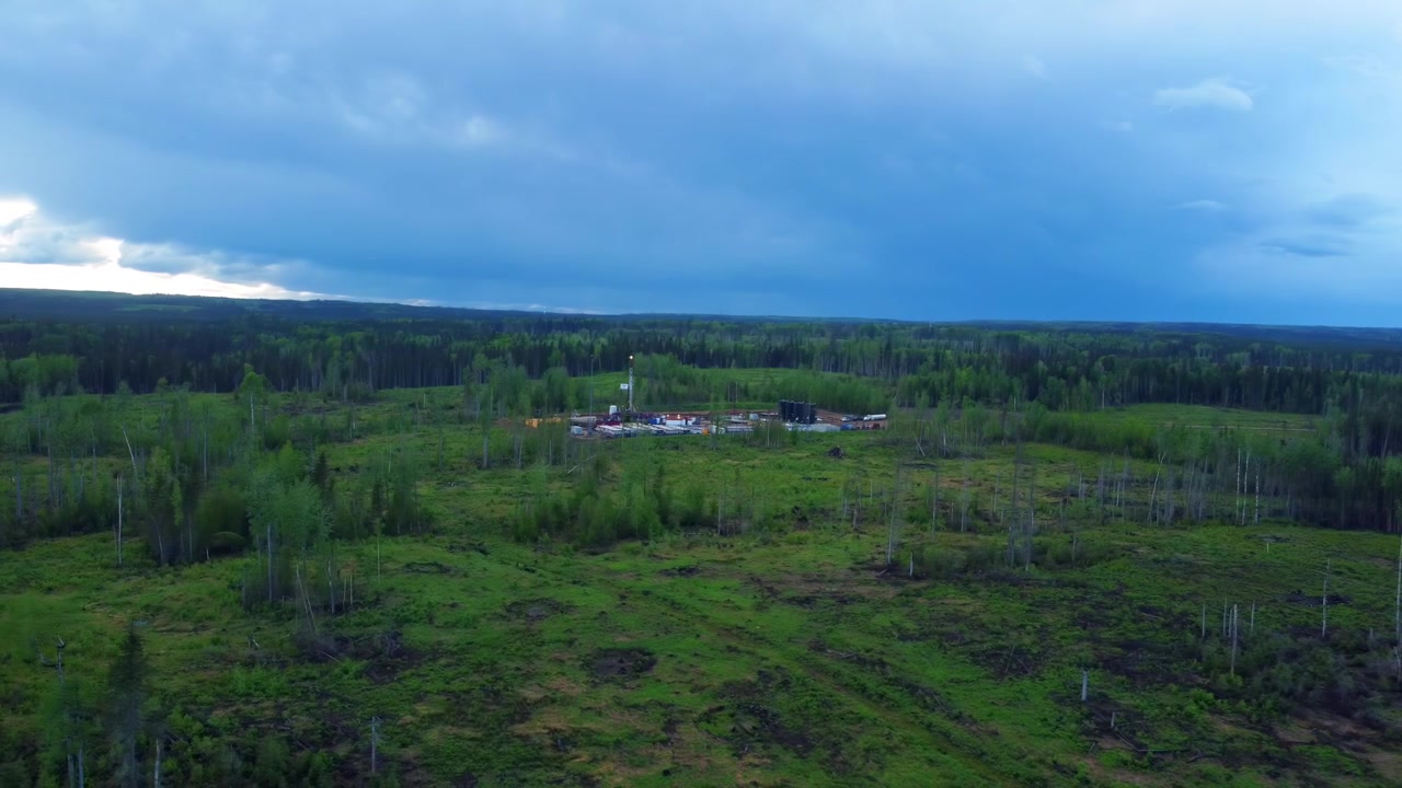 Vista aerea di una piattaforma di perforazione remota con cieli piovosi in Alberta.