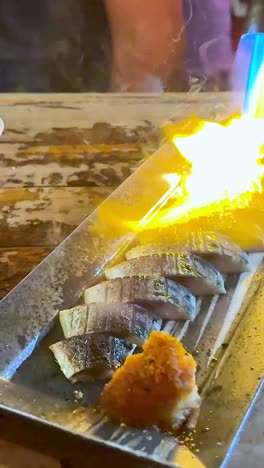 Chef torches sushi for enhanced flavor and presentation