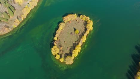pequeña isla del lago con árboles de color amarillo en la orilla en el brazo de wairepo