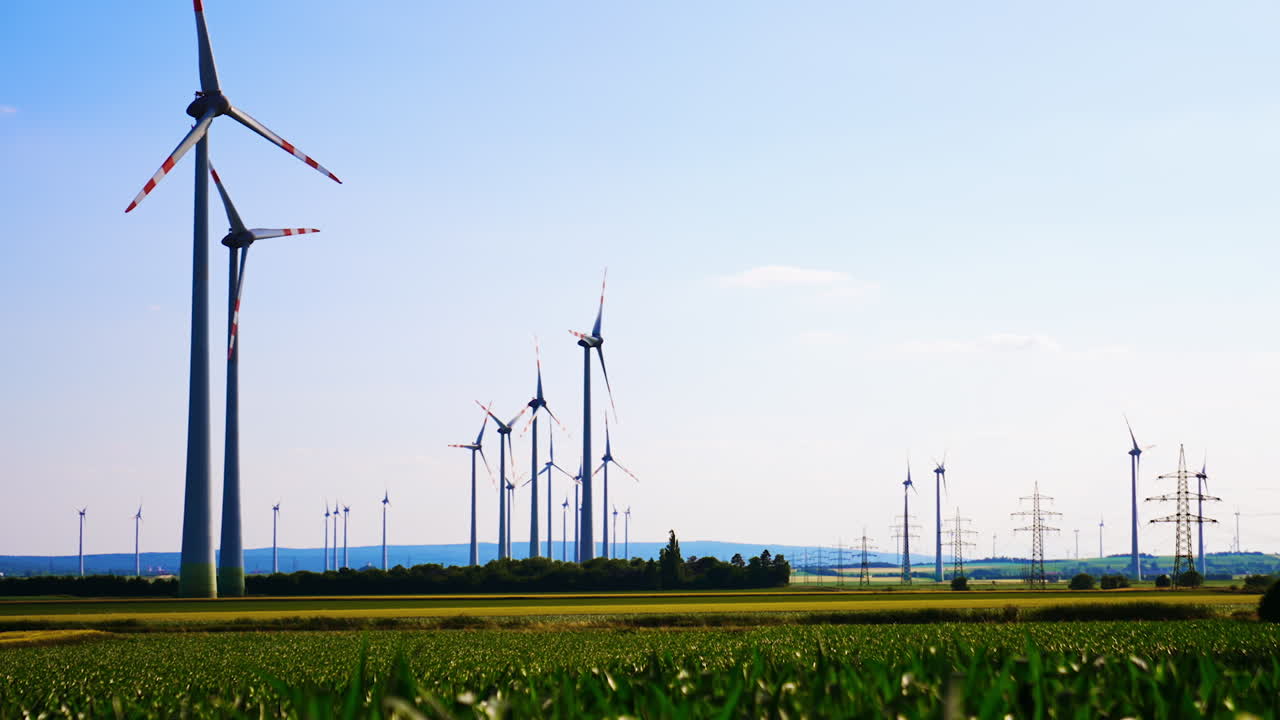 Sunny day with wind turbines. Renewable energy harnessed from wind in a rural landscape featuring multiple wind turbines under a clear blue sky