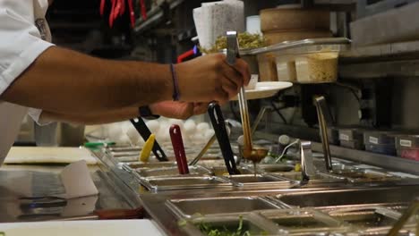 Sauce-being-poured-into-a-dish-in-a-restaurant-kitchen