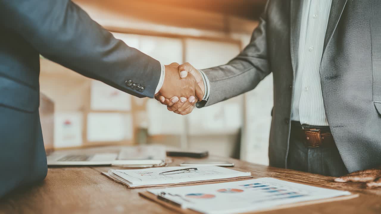 Een succesvol partnerschap: twee professionals geven elkaar een stevige handdruk tijdens een zakelijke bijeenkomst, als symbool van vertrouwen en samenwerking voor toekomstige projecten en kansen.