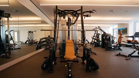 a focused push-in shot of a workout machine within a well-equipped fitness center