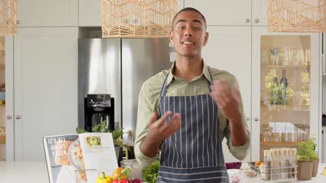 Vlogger-De-Cocina-Masculino-Birracial-En-Delantal-Hablando-Y-Filmando-En-La-Cocina