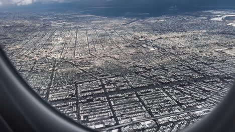 los barrios de brooklyn y queens de la ciudad de nueva york cubiertos de nieve, vistos desde la ventana de un avión