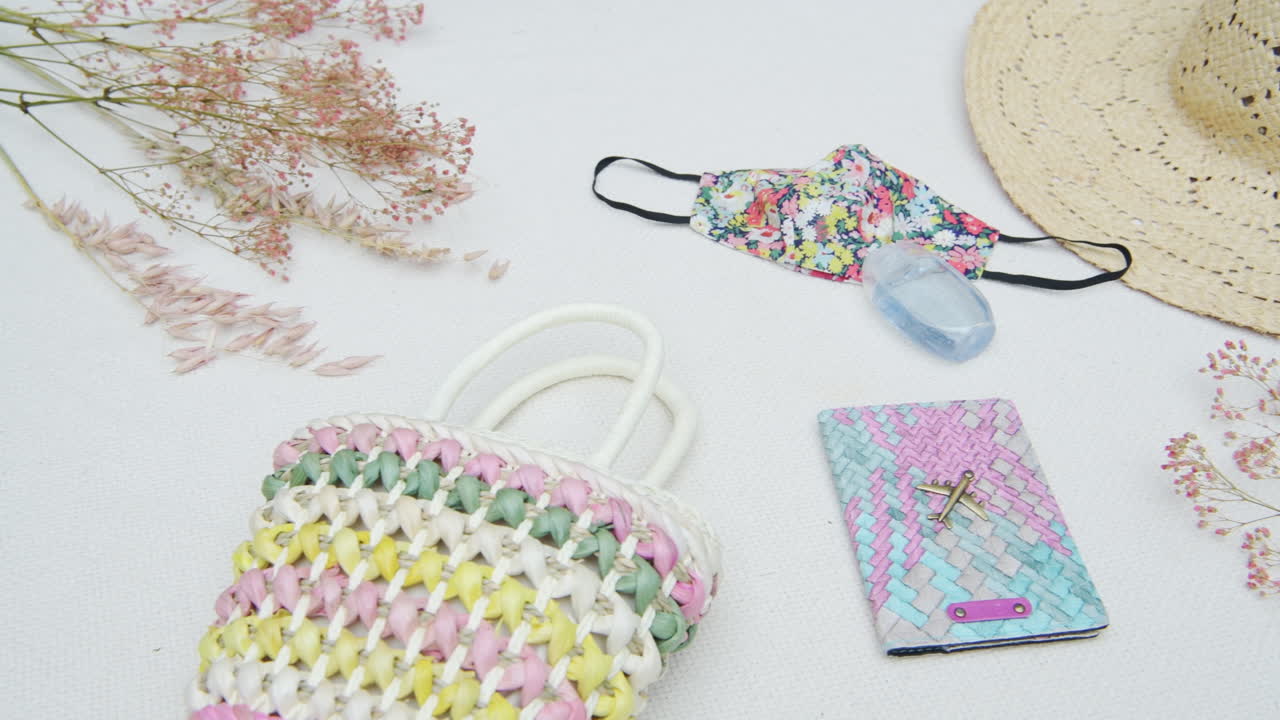 Feminine Cloth Face Mask In Floral Design With Pastel Colored Passport Holder And Handbag - Coronavirus Travel Flatlay - overhead shot