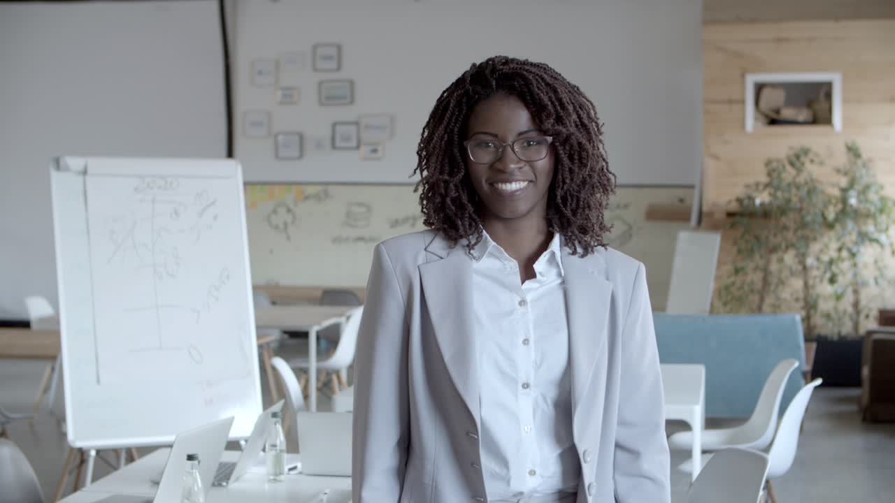 alegre mujer de negocios afroamericana sonriendo a la cámara