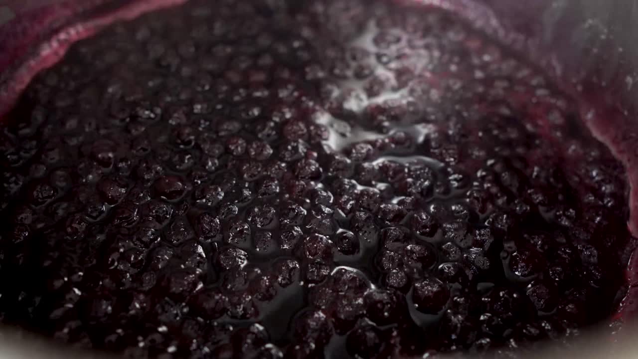 스토브에서 요리하는 동안 끓는 블루베리 소스가 김을 내뿜습니다.