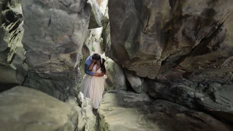 groom with bride standing in cave of mountain hills. wedding couple in love