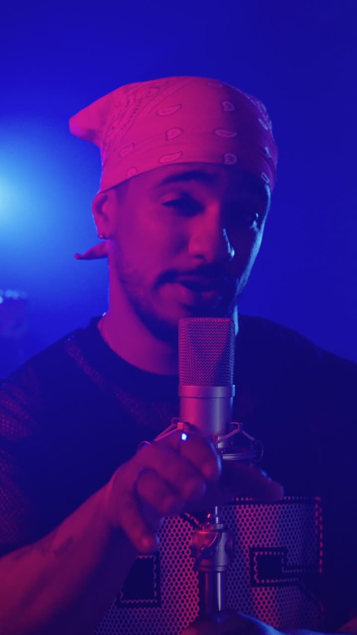 Man singing into a microphone with a bandana