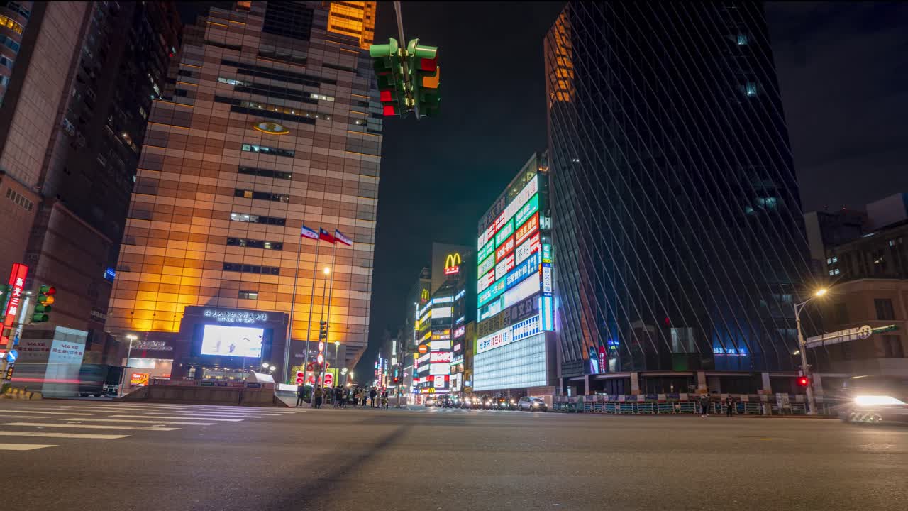 Panning View of Night City Time Lapse From Left to Right at Zhongxiao West Road Busy Intersection with Traffic and Pedestrians in Metropolitan Taipei Taiwan.