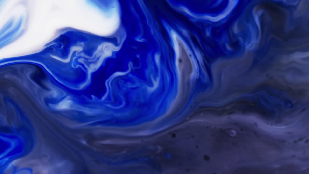 Video ravvicinato di inchiostro blu e bianco in acqua con spazio per il testo.