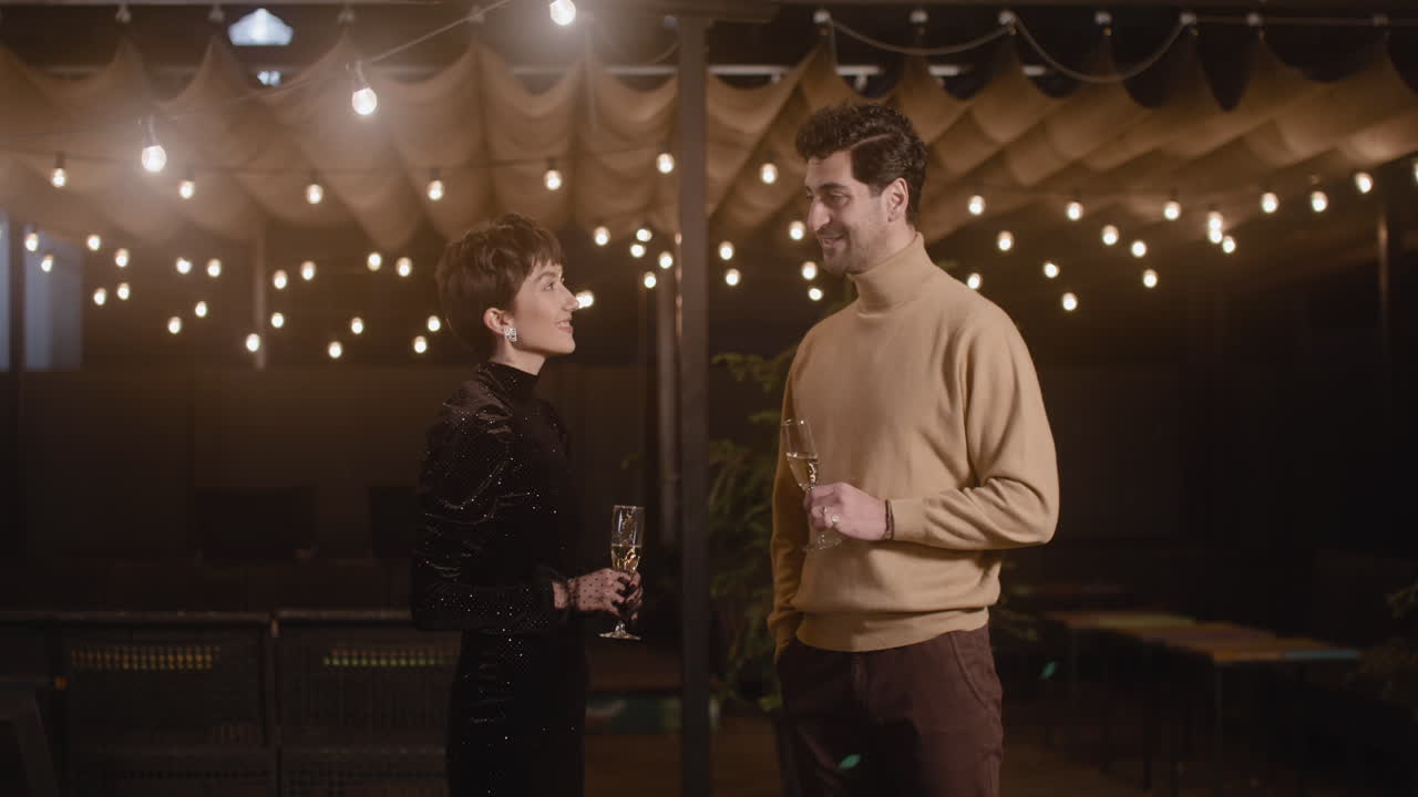 새해 전야 파티에서 샴페인을 마시고 이야기하는 우아한 여성과 잘생긴 남자 1