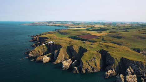 Flying-High-Over-Scotland-and-British-Isles:-The-Rocky-Shores-of-St-Abbs-Head,-Iconic-Scottish-Landmark-on-North-Sea