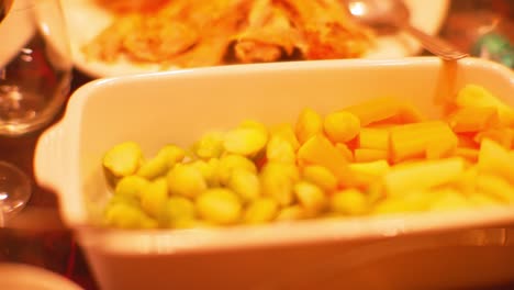 dish with rabbit in red wine sauce and bowl with brussels sprouts and carrot