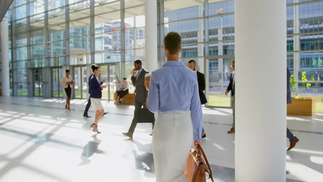donna d'affari caucasica che cammina nella hall dell'ufficio 4k