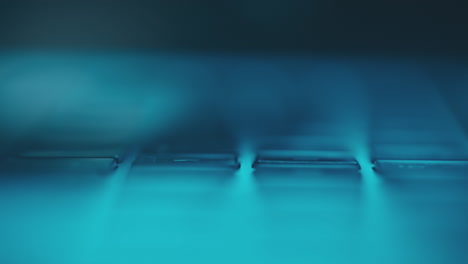 primer plano de las manos escribiendo en un teclado de portátil por la noche