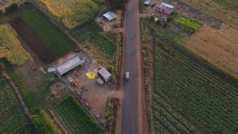 Drohne-Folgt-Inova-Auto-Von-Oben-In-Ländlichem-Dorf-Farm-Road-Filmisch-Bei-Sonnenuntergang-Sonnenaufgang