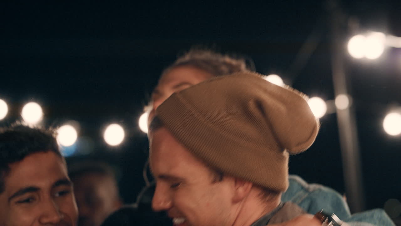 un grupo joven de amigos multirraciales divirtiéndose bailando juguetón juntos disfrutando de una fiesta en la azotea por la noche riendo celebrando la amistad