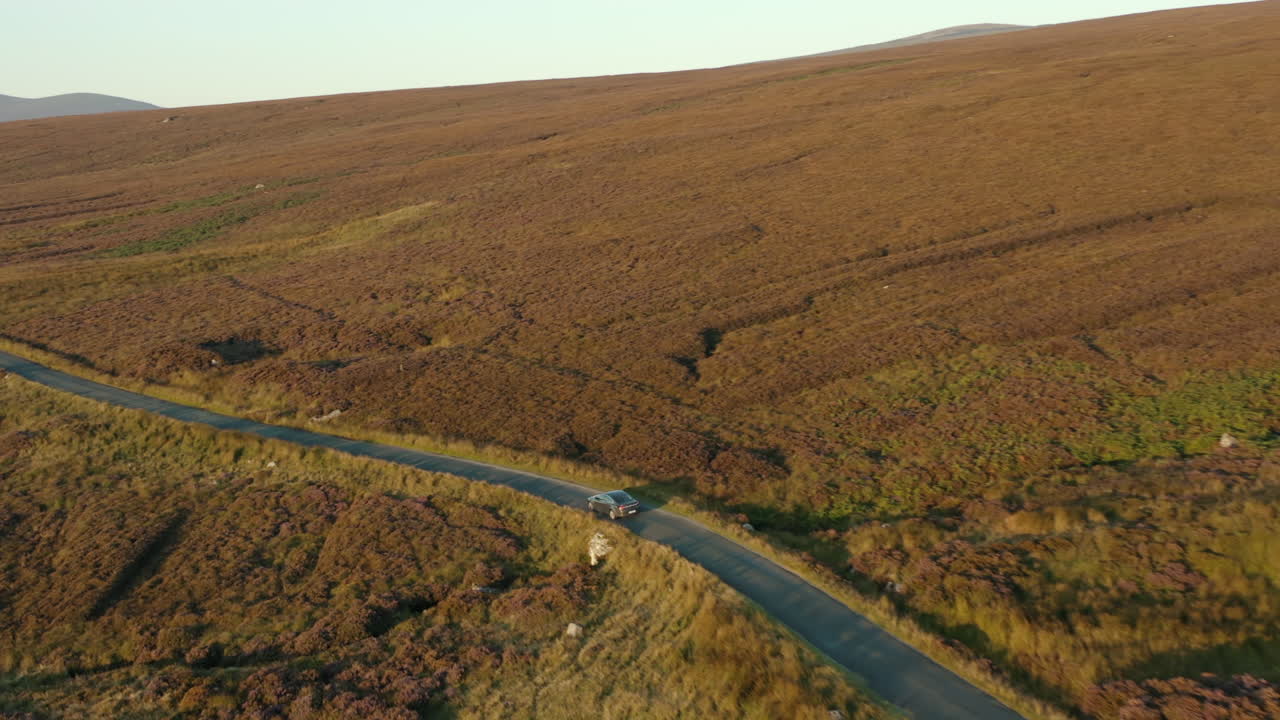 vista aérea, toma de seguimiento, 4k, imágenes de drones siguiendo a un automóvil conduciendo por una carretera de montaña