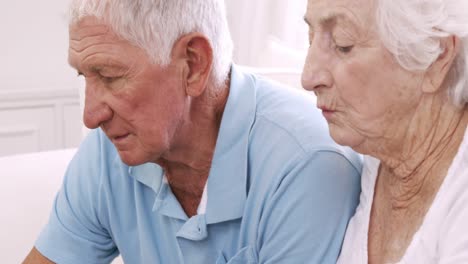 una pareja de ancianos usando una computadora portátil y hablando