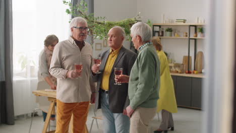 senior men toasting with wine at home dinner party