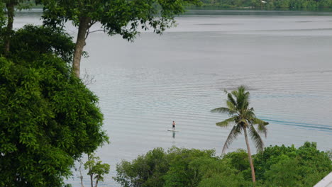 tropical seascape with person paddle boarding in moso island, coast of efate, vanuatu, shefa province