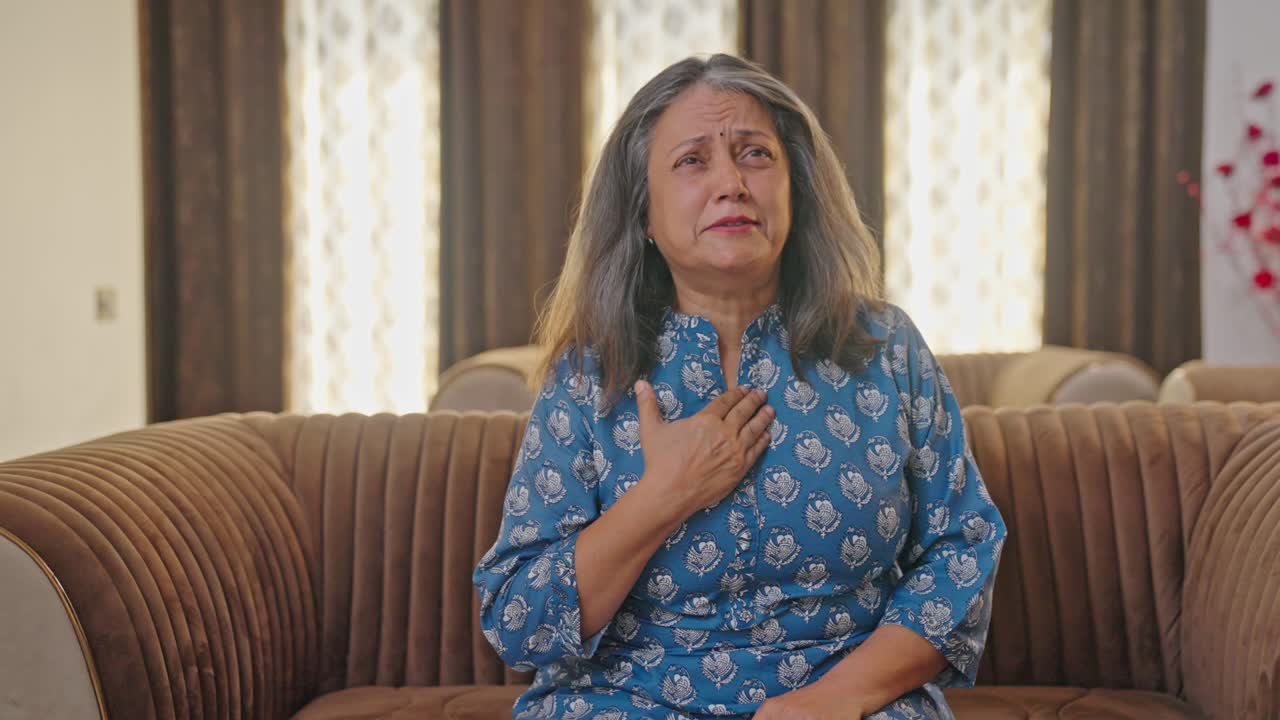 Anziana donna indiana che soffre di problemi gastrici e di acidità