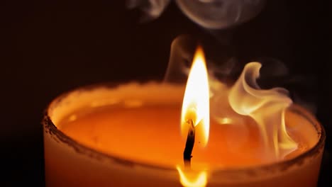 close-up of a burning candle with smoke