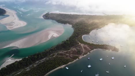 sailboats along noosa river during misty morning in noosa north shore, queensland, australia