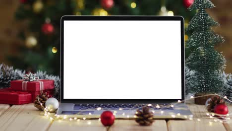 Laptop-with-copy-space-on-screen,-with-christmas-decorations-and-tree