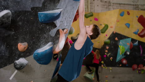 muchacho adolescente bouldering en el interior