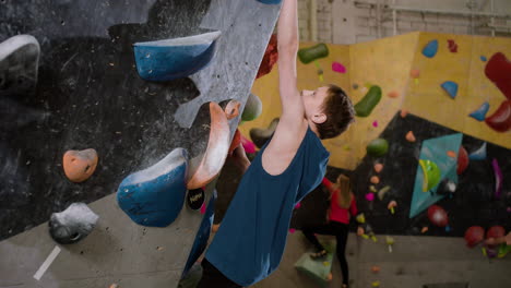 teenage boy bouldering indoors