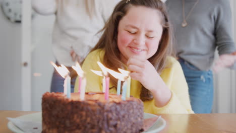 young downs syndrome couple celebrating birthday at home with cake