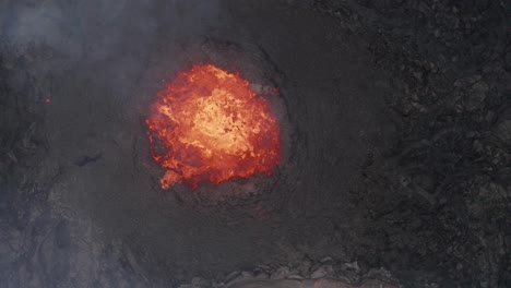 top view of bubbling lava in the mouth of volcanic eruption in geldingadalur, iceland - aerial drone shot