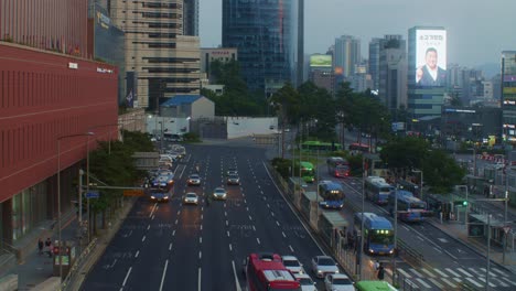 south korea seoul station city town centre urban traffic road with cars, buses and crowded places in the evening with buildings skyscrapers and billboards