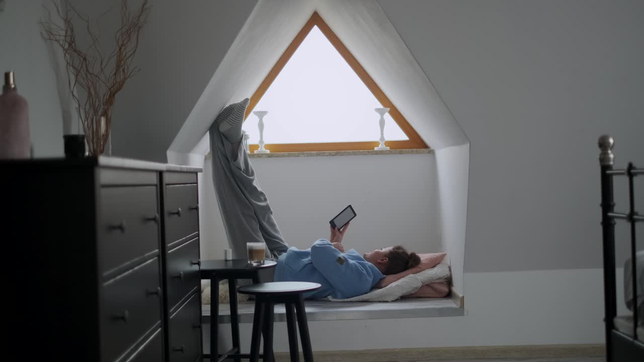 Woman Relaxing in Attic Window Seat
