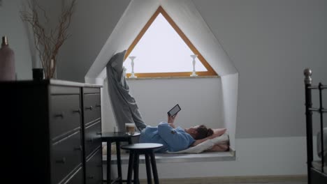 woman relaxing in attic window seat