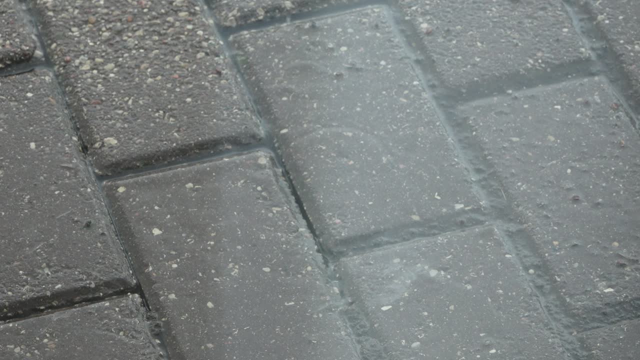 las gotas de lluvia caen sobre un camino pavimentado